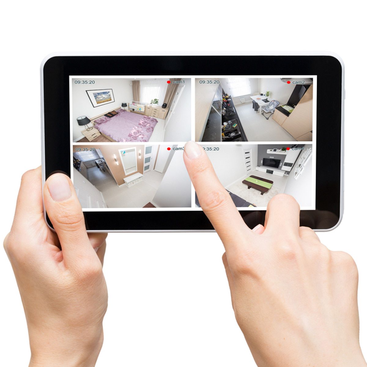 A hand interacts with a tablet displaying multiple security camera feeds of different rooms, showing interiors with furniture and lighting.