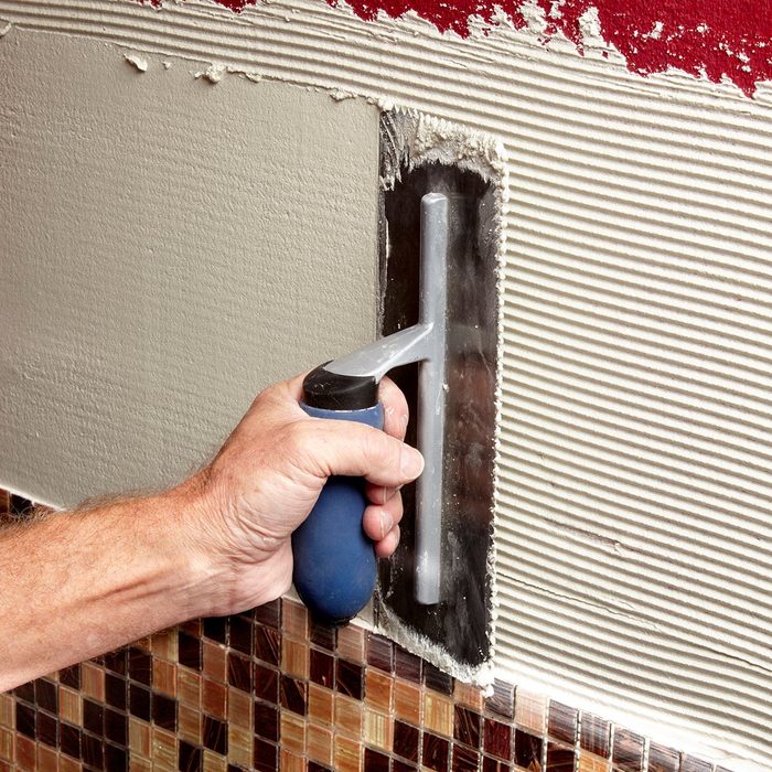 applying thin set to the walls | Construction Pro Tip