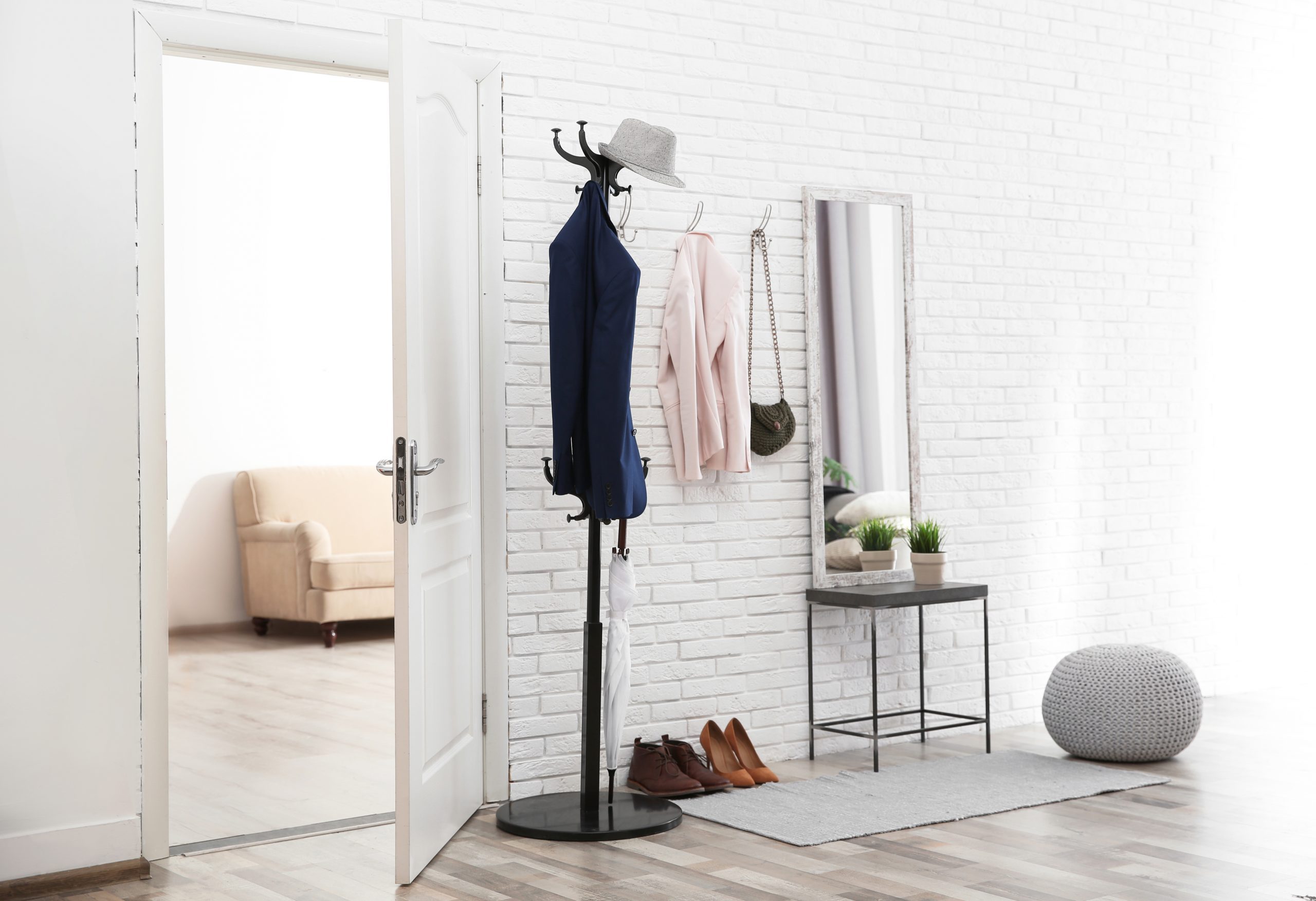 Stylish hallway interior with door and comfortable furniture