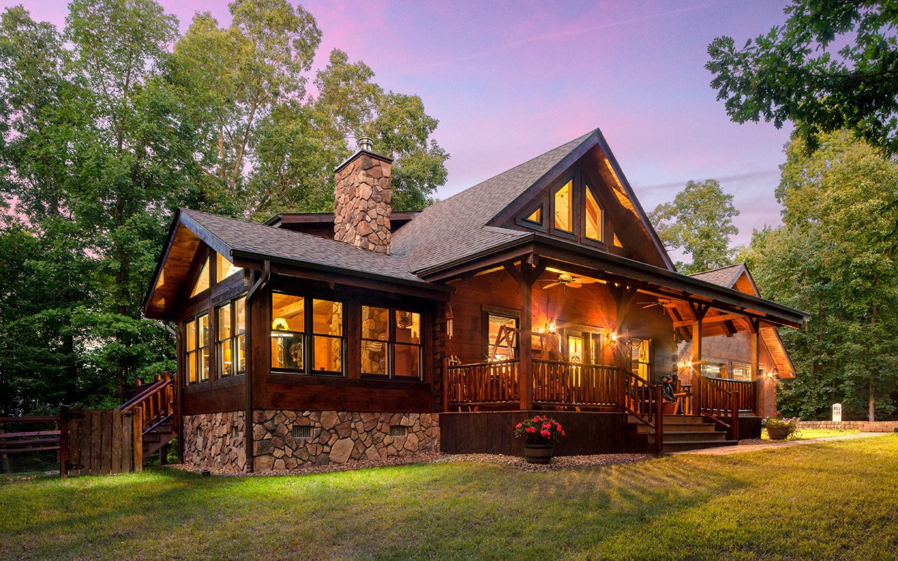 Lit-up log home at dusk
