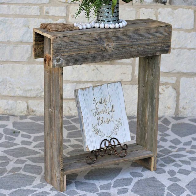 A rustic wooden table holds a small potted plant and a sign reading 