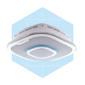 A ceiling-mounted speaker emits sound waves in a light blue grid-background setting, blending into a modern interior design context.