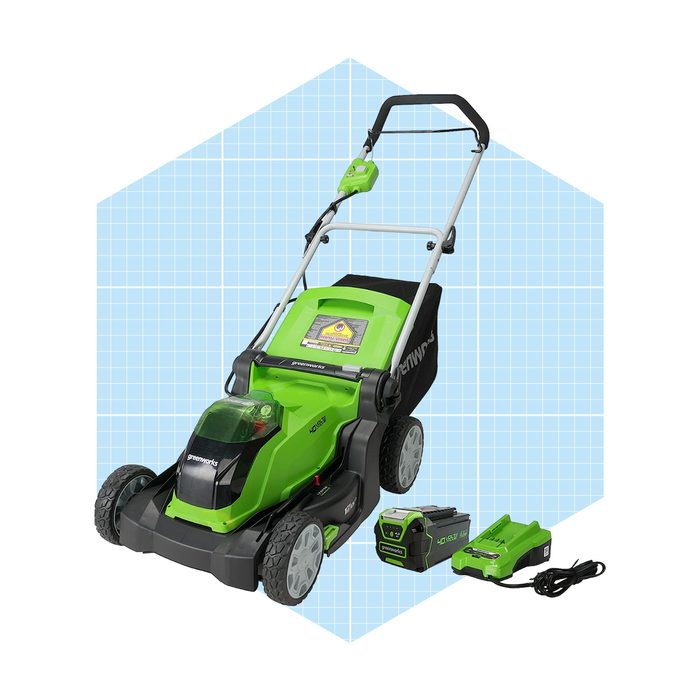 A green and black electric lawn mower stands upright, with battery units beside it. It is displayed against a light blue geometric background.