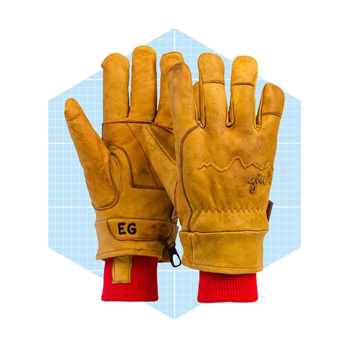 Leather gloves with red cuffs are displayed open, showcasing their texture and design against a light blue geometric background.