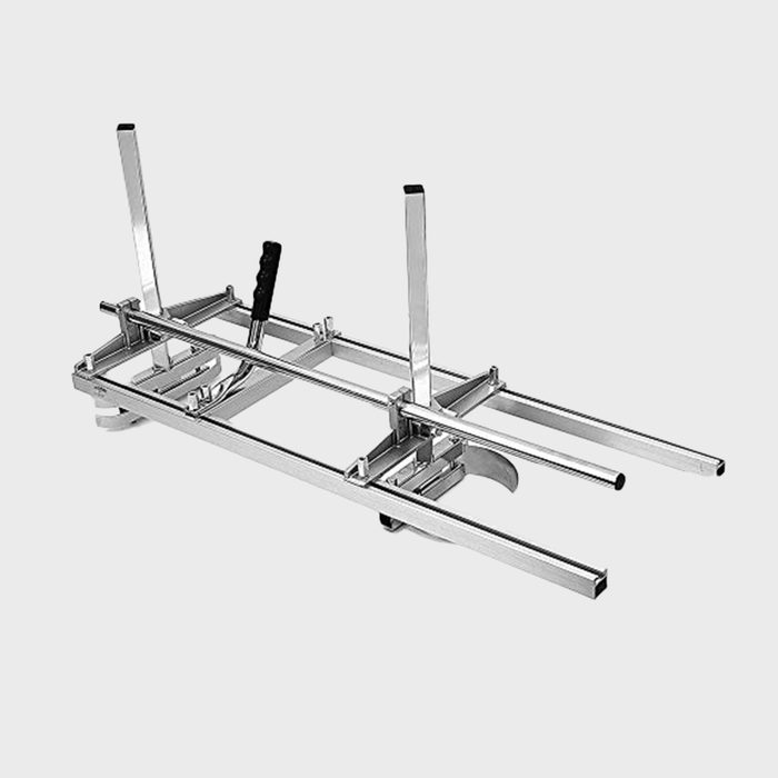 A metal frame with handles and wheels is positioned for use, designed to assist in moving or supporting objects, typically in a workshop or storage environment.