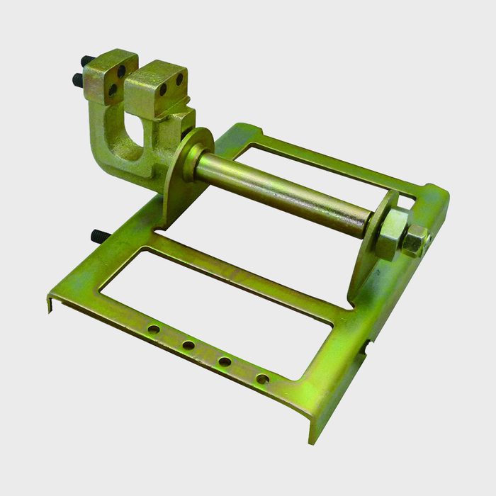 A metallic clamp with an adjustable rod secures items, set against a plain background, facilitating construction or repair tasks in various environments.