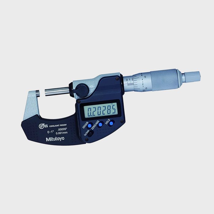 A digital micrometer measures a small object, displaying a reading of 0.20285 mm on its clear screen, with a robust design for precision.
