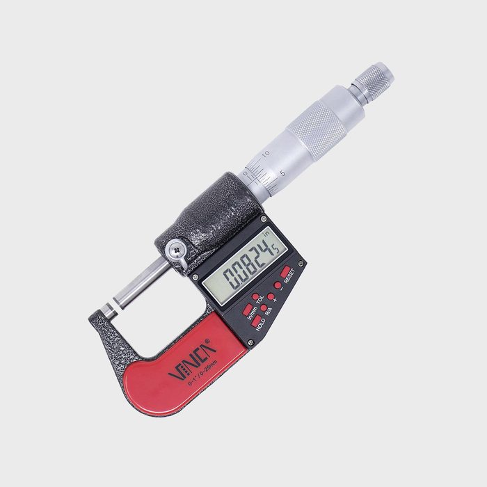 A digital micrometer measures small lengths, displaying a reading of 0.0824 inches on its screen, set against a plain light background.
