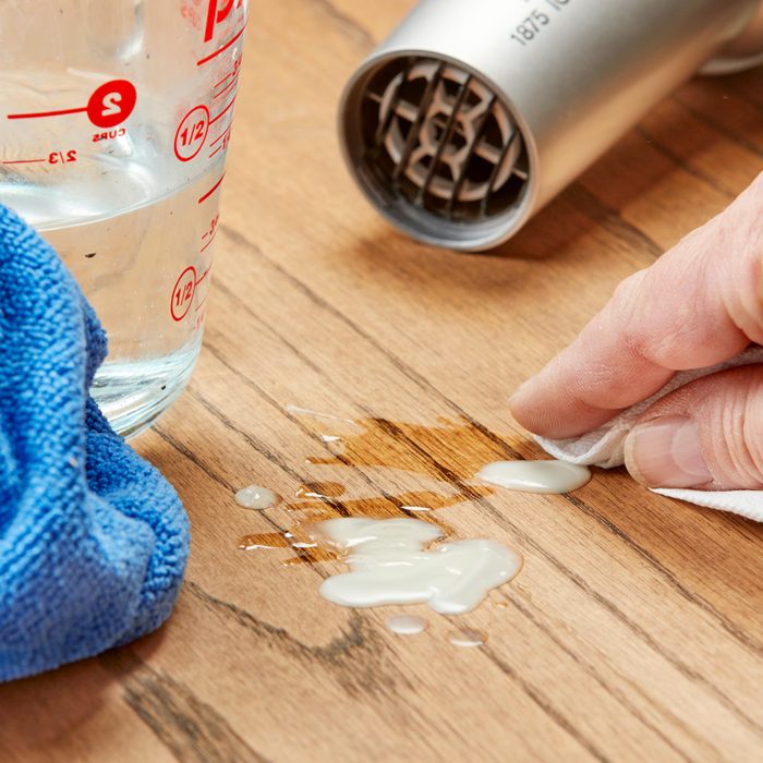 cleaning up candle wax on a wooden table