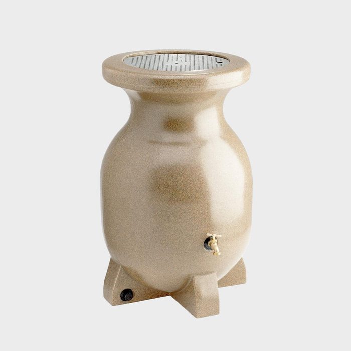 A beige ceramic object, resembling an urn, stands upright, equipped with a top perforated surface and a side valve, in a neutral background.