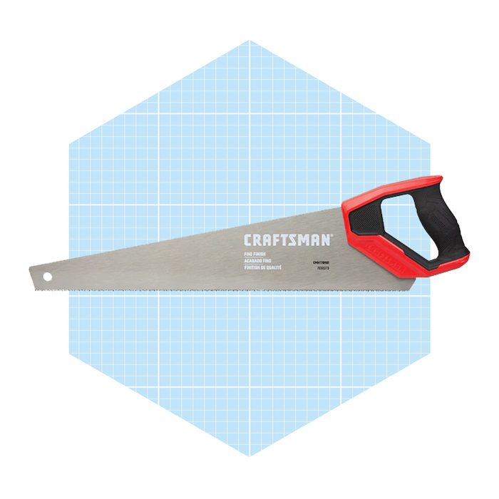 A hand saw rests diagonally on a light blue hexagonal background with a grid pattern, showcasing its silver blade and red handle.