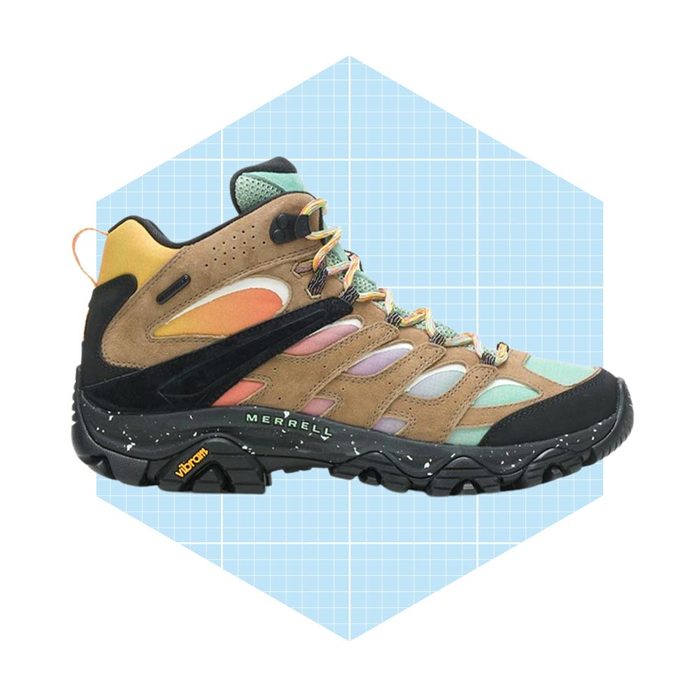 A hiking boot is displayed, featuring a colorful design and rugged sole, positioned against a light blue hexagonal grid background.