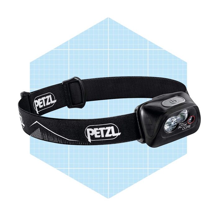 A black headlamp with two light beams is mounted on an adjustable strap, set against a light blue geometric background.