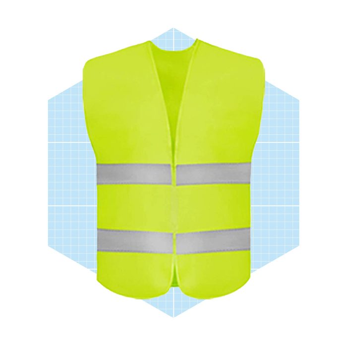 A bright yellow safety vest with two horizontal reflective stripes stands prominently against a light blue grid background, indicating visibility and protection in various environments.