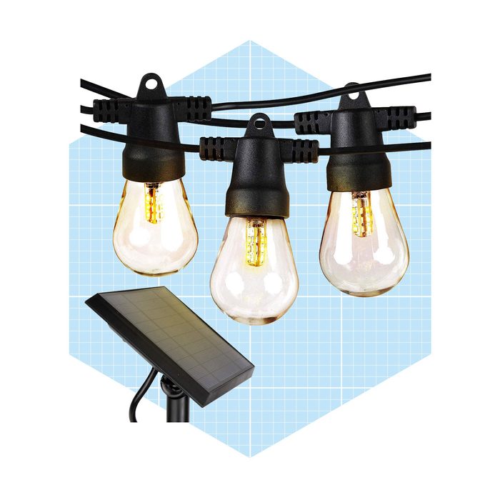 Three hanging light bulbs illuminate as they’re connected to a black wire, with a solar panel positioned below against a blue grid background.