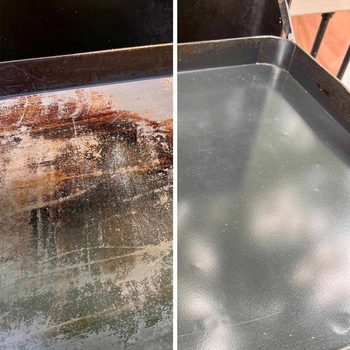 A metal tray shows contrasting sections: one side is rusty and dirty, while the other is clean and shiny, reflecting light from the surroundings.